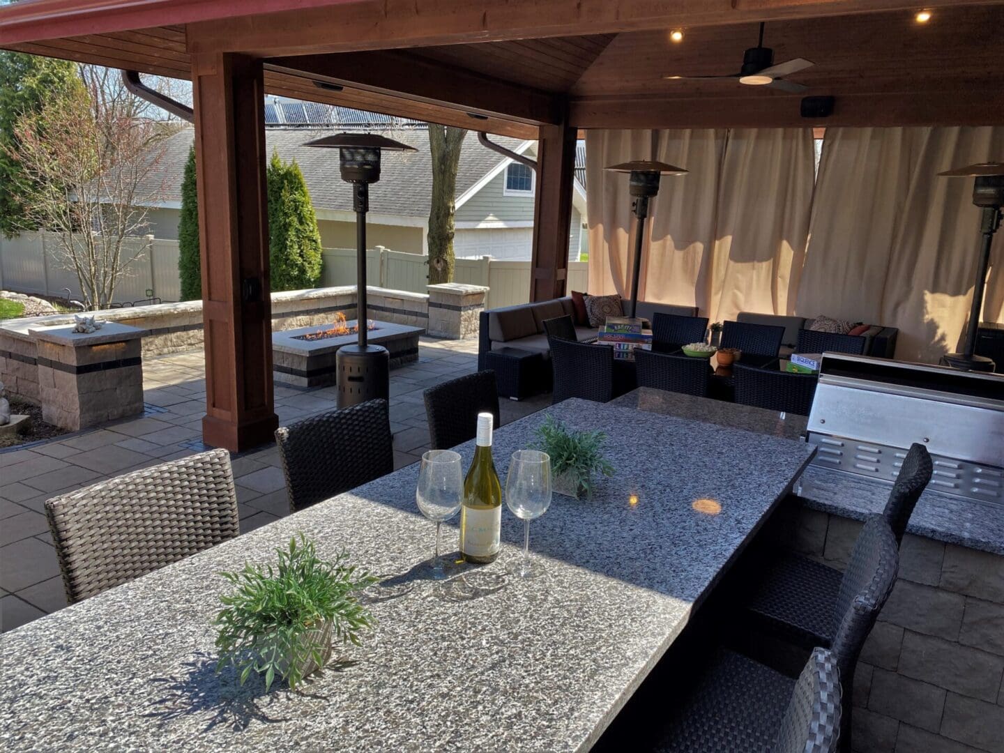Luxury backyard pavilion installation with custom wood design, grill, bar, and firepit in Downers Grove, IL