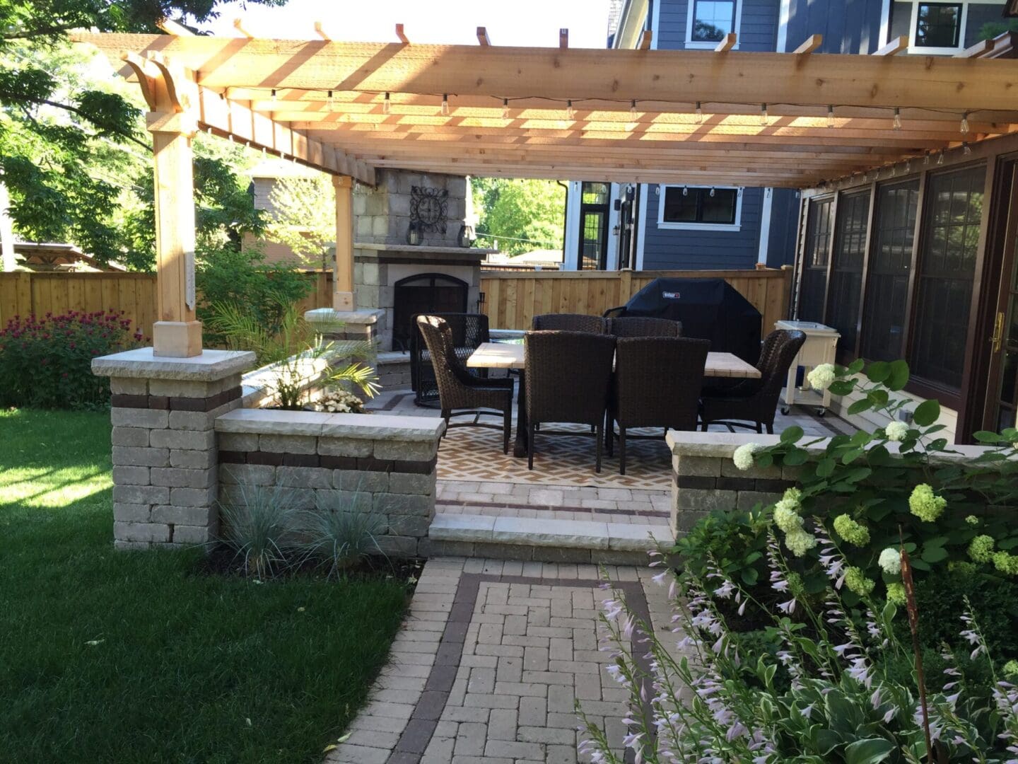 High-end pergola with fireplace, seating walls, paver patio and landscape lighting in Downers Grove, IL