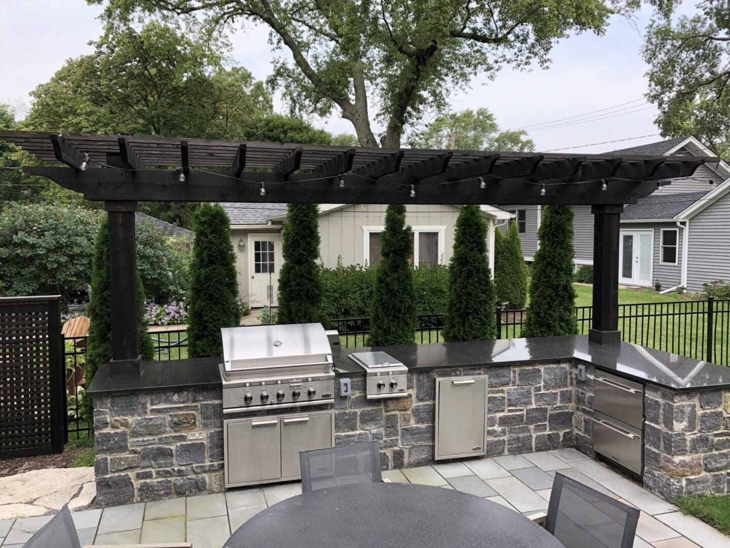 Wood pergola and outdoor kitchen with built in grill and refrigerator in Clarendon Hills, IL