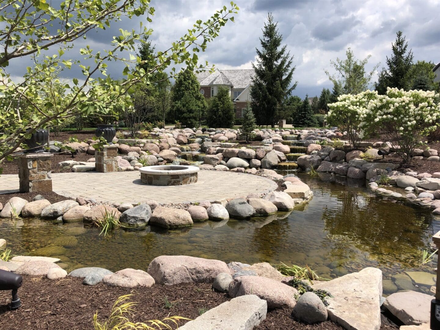 Custom paver patio with fire pit and pond in Palos Park, IL